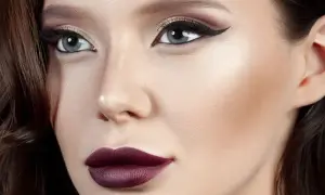 Elegancki makijaż do bordowej sukienki: ciemna szminka, kreska na oku i subtelne cienie.
