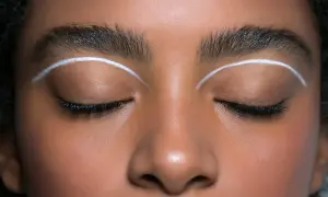 Oczy z makijażem w stylu cut crease, podkreślone białymi liniami nad powiekami.
