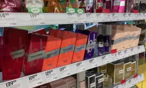Półki z perfumami w drogerii, w tym flakony w kształcie czaszek i pudełka z marką Bruno Banani.