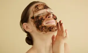 Kobieta z maseczką z kawy na twarz, ciesząca się domowym spa.