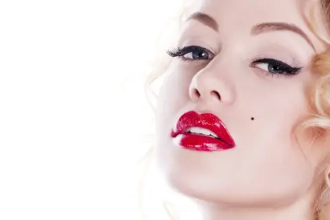 Blond włosy, czerwone usta i pieprzyk – klasyczny efekt Marilyn Monroe.