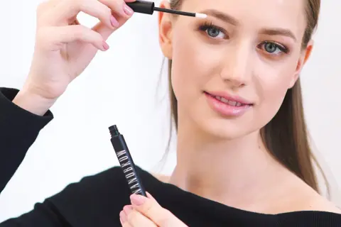 Kobieta aplikuje produkt do brwi Nanobrow, tworząc perfekcyjny makijaż.