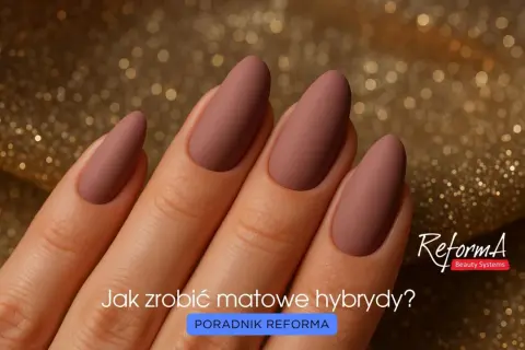 Dłoń z eleganckimi, matowymi paznokciami w odcieniu pudrowego różu na złotym, błyszczącym tle. Pytanie "Jak zrobić matowe hybrydy?" zachęca do nauki.