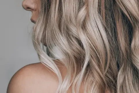 Piękne, falowane blond włosy z refleksami. Dowiedz się, jak rozjaśnić włosy w domu, by uzyskać taki efekt.
