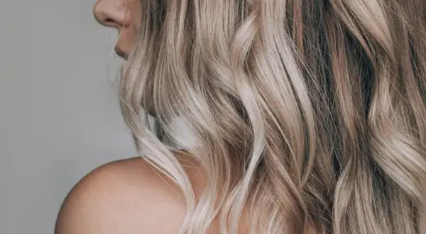 Piękne, falowane blond włosy z refleksami. Dowiedz się, jak rozjaśnić włosy w domu, by uzyskać taki efekt.
