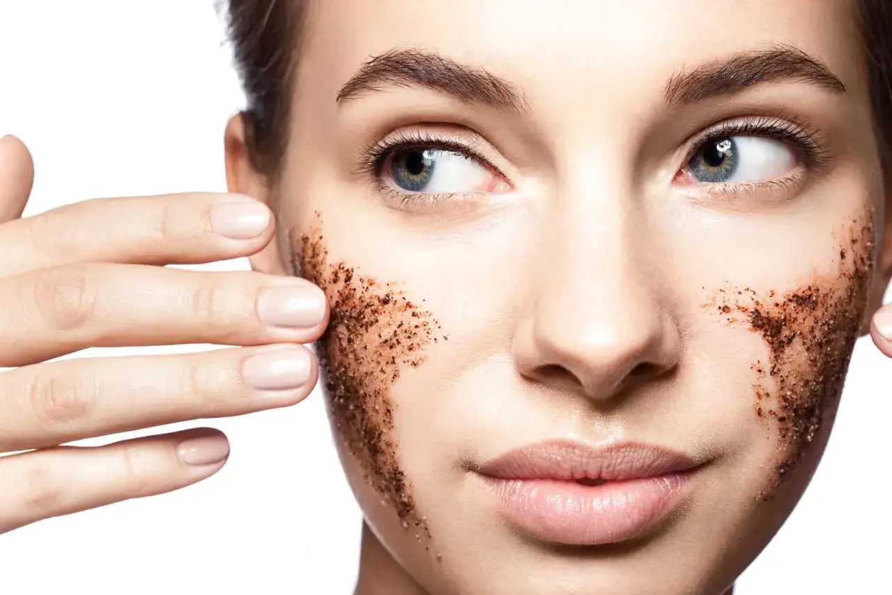 Kobieta aplikuje na twarz drobnoziarnisty peeling kawowy. Zastanawiasz się, jaki peeling do twarzy wybrać? Ten naturalny może być świetnym rozwiązaniem.