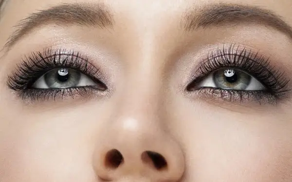 Oczy z perfekcyjnym makijażem smokey eyes, długimi rzęsami i subtelnym połyskiem na powiekach.