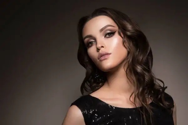 Elegancki makijaż do czarnej sukienki: smoky eyes, błyszczące powieki i matowe usta. Idealny na wieczorne wyjście.